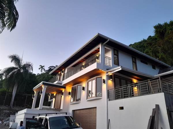 Smart villa hillside exterior with lighting at dusk in Jacks Hill, Kingston