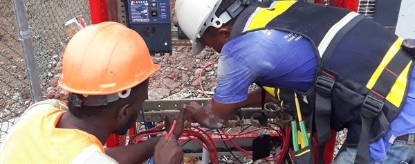 Electricians terminating wiring on a distribution board